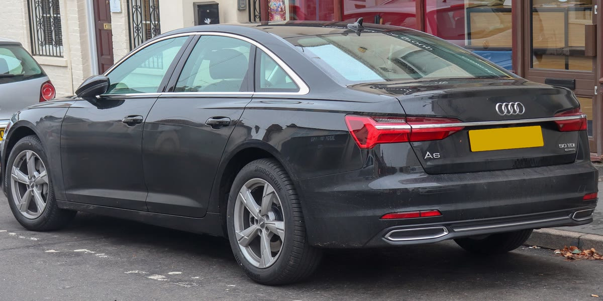 Original rear-corner Audi photo with shop windows and another parked car in the background